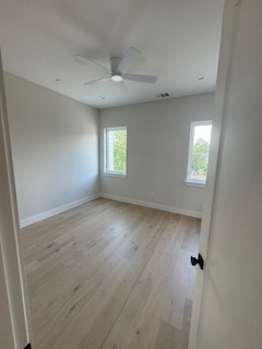 Bedroom with two windows and wood flooring Bedroom with two windows and wood flooring