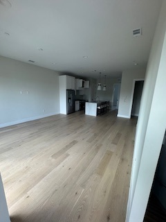 Open-concept living area with kitchen island in the background Open-concept living area with kitchen island in the background
