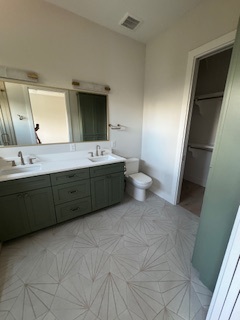Primary bathroom with dual-sink vanity and walk-in closet Primary bathroom with dual-sink vanity and walk-in closet