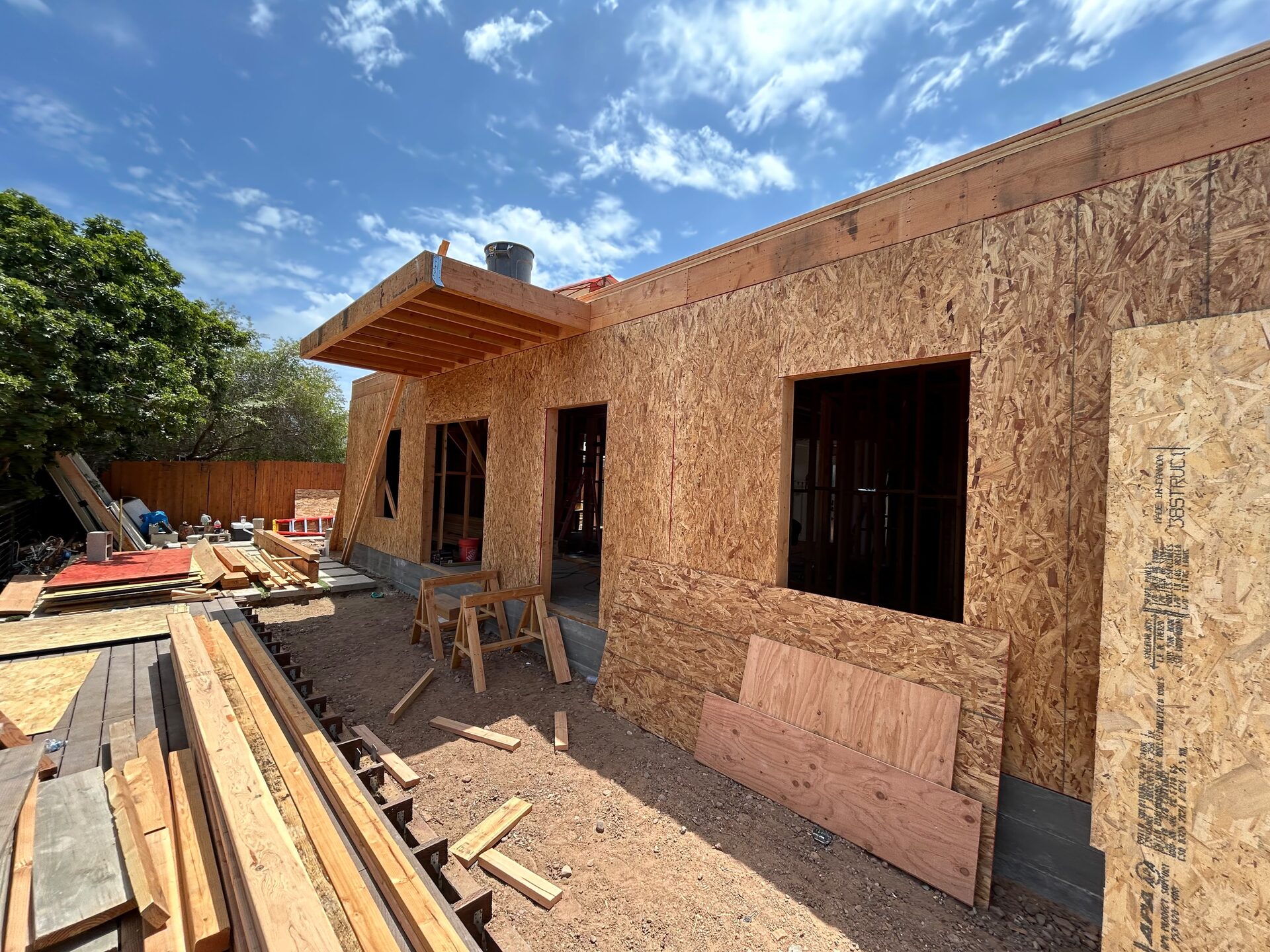 Exterior OSB sheathing on the new addition with materials staged on site